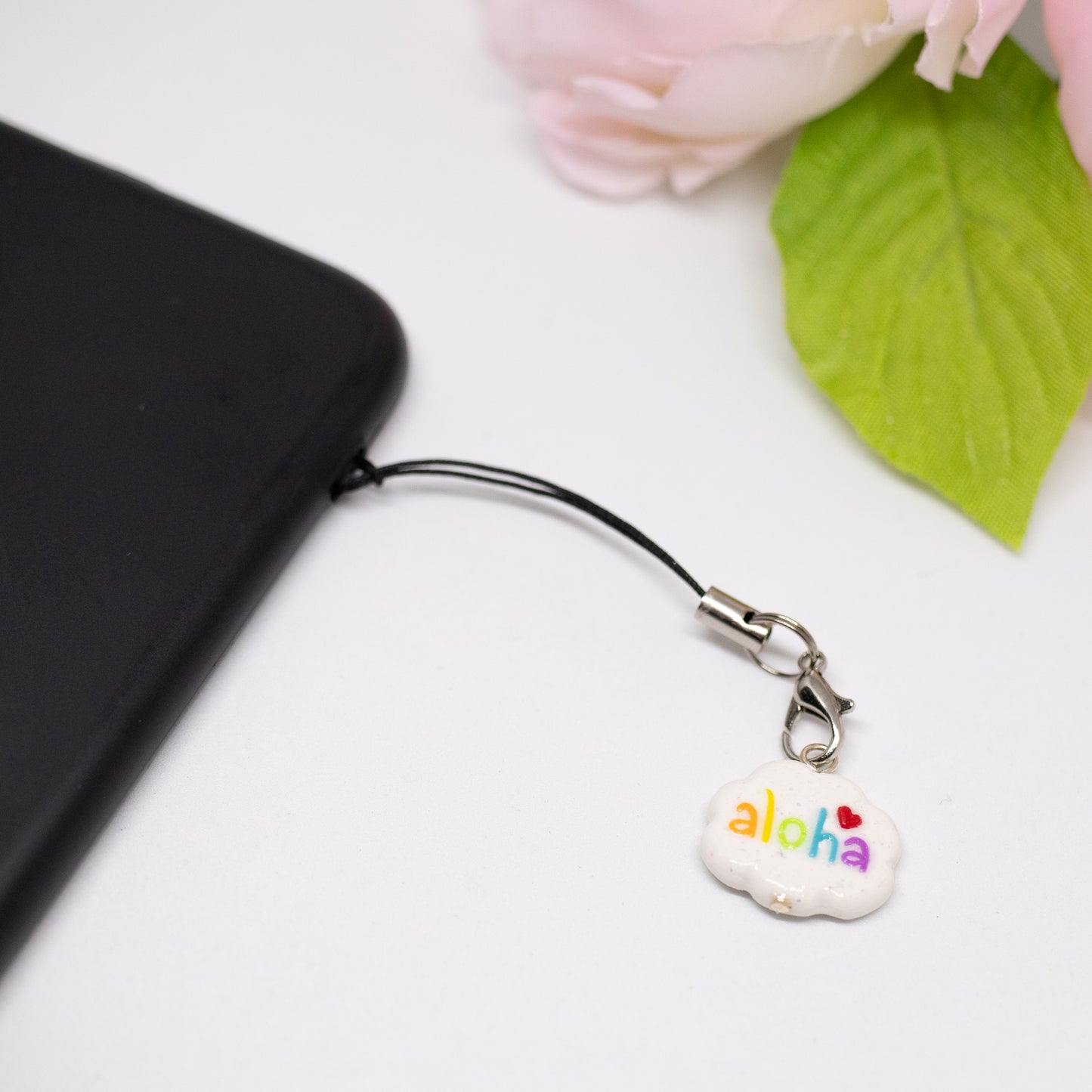 Handmade polymer clay aloha cloud charms. This cloud charm comes with a phone strap and spells out the word aloha in rainbow colors.