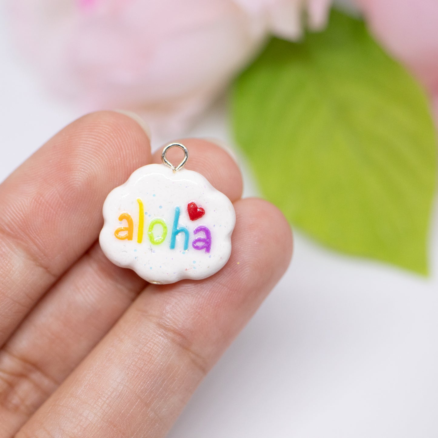 Handmade polymer clay aloha cloud charms. This cloud charm comes with a phone strap and spells out the word aloha in rainbow colors.