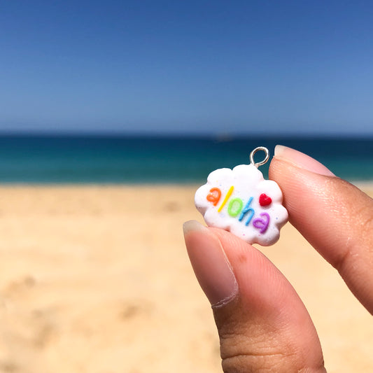 Handmade polymer clay aloha cloud charms. This cloud charm comes with a phone strap and spells out the word aloha in rainbow colors.