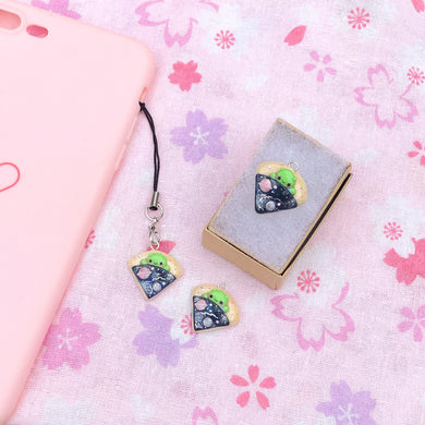 A simple alien pizza charm. This little charm has a tiny, green alien tucked inside a pizza. The pizza is galaxy-themed, with little planets, stars and glitter. This charm can be attached onto a cellphone, planner or purse!