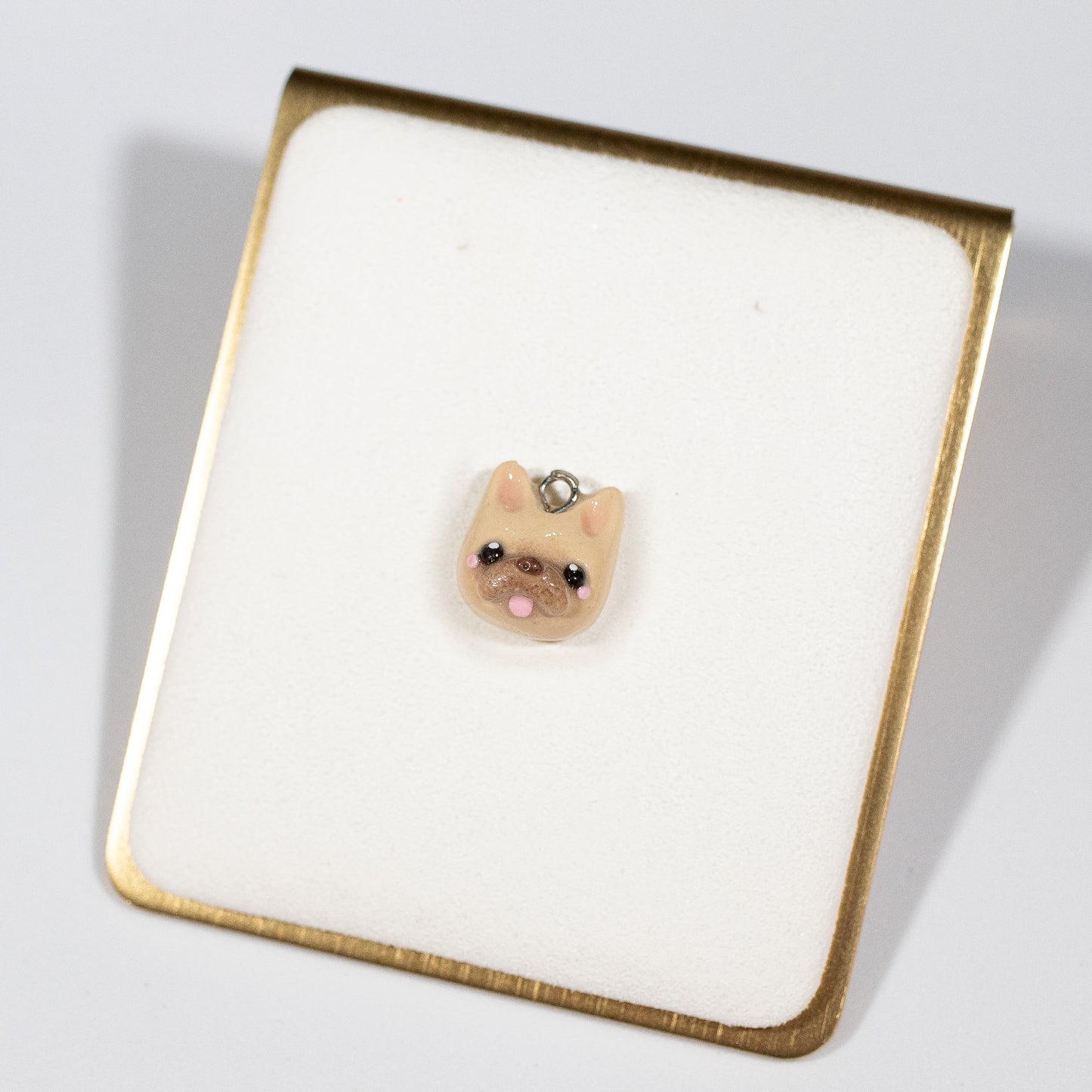 Cute and simple French bulldog charms! These little doggies have little blushing cheeks and a tongue that sticks out. Available in two colors: tan and black/white. Handmade from polymer clay, glazed with resin. A complimentary phone strap is included. Charm can be attached to a cell phone, purse, stitch marker, earrings, and more!