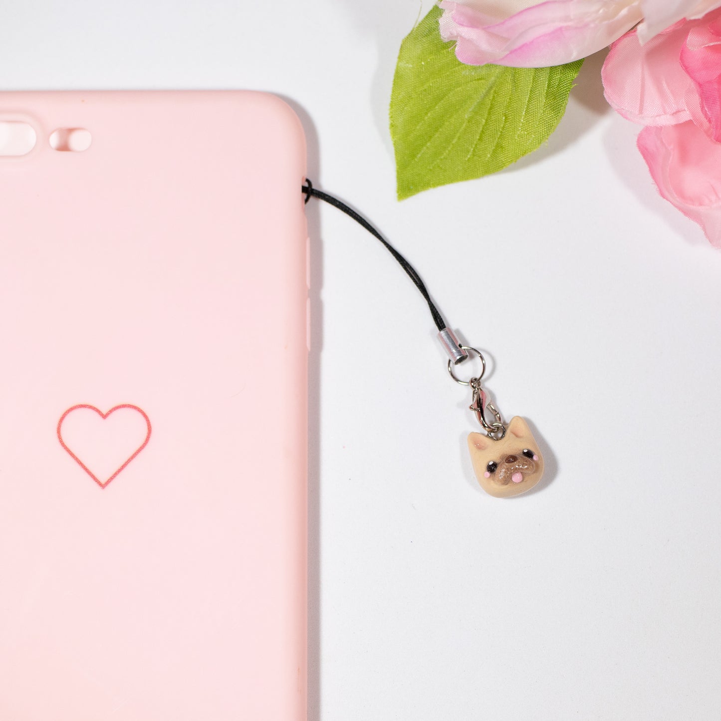 Cute and simple French bulldog charms! These little doggies have little blushing cheeks and a tongue that sticks out. Available in two colors: tan and black/white. Handmade from polymer clay, glazed with resin. A complimentary phone strap is included. Charm can be attached to a cell phone, purse, stitch marker, earrings, and more!