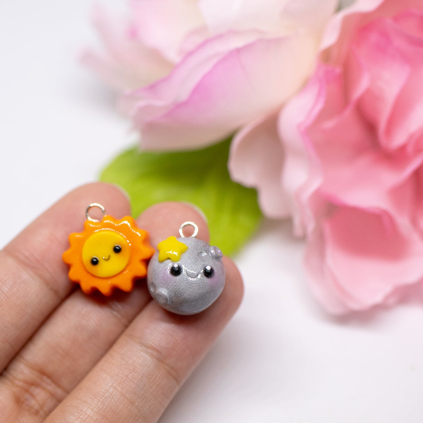 Our sun and moon clay charms on phone cases. These matching charms both have cute happy faces and pink blush.