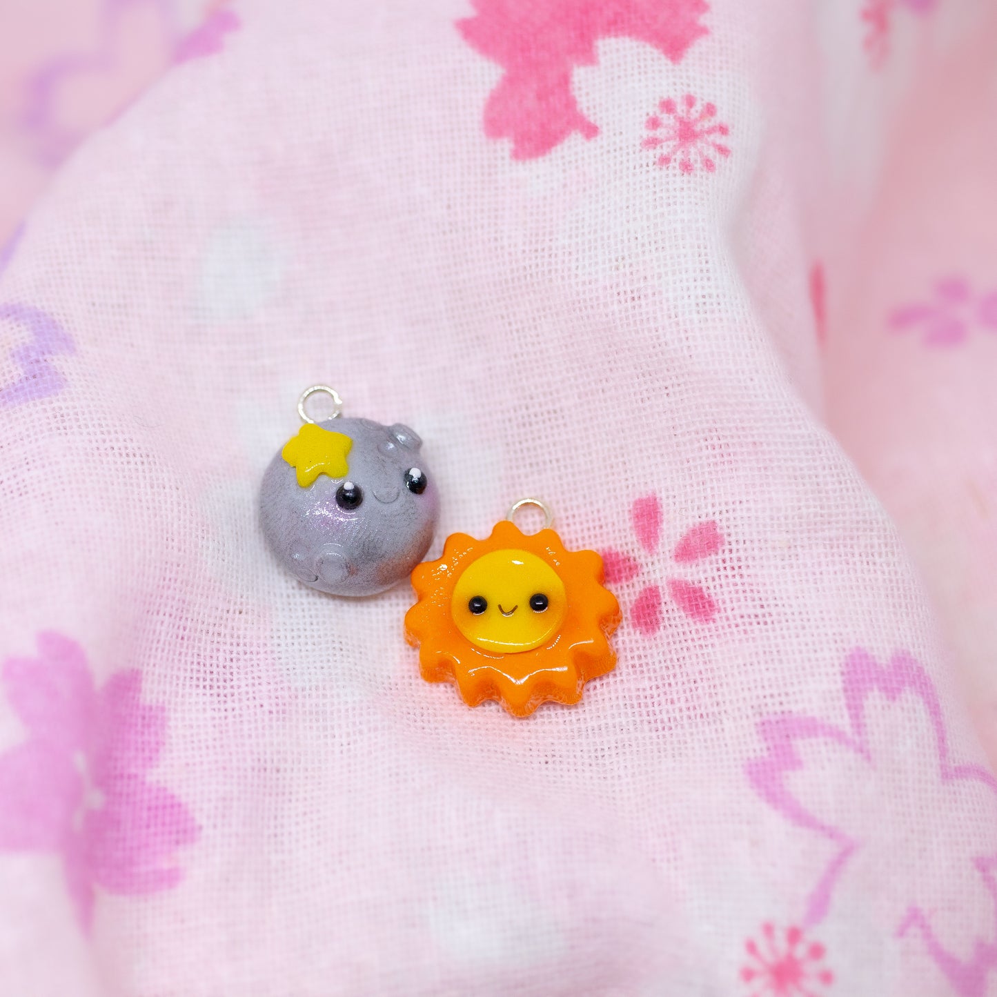 Our sun and moon clay charms on phone cases. These matching charms both have cute happy faces and pink blush.