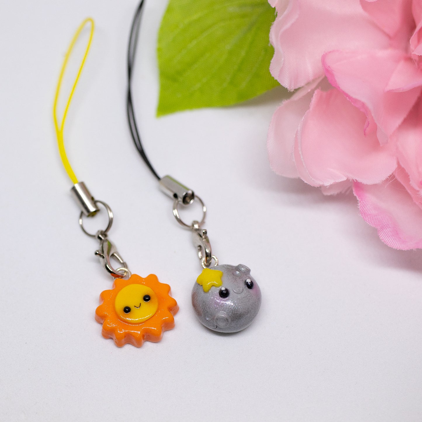Our sun and moon clay charms on phone cases. These matching charms both have cute happy faces and pink blush.
