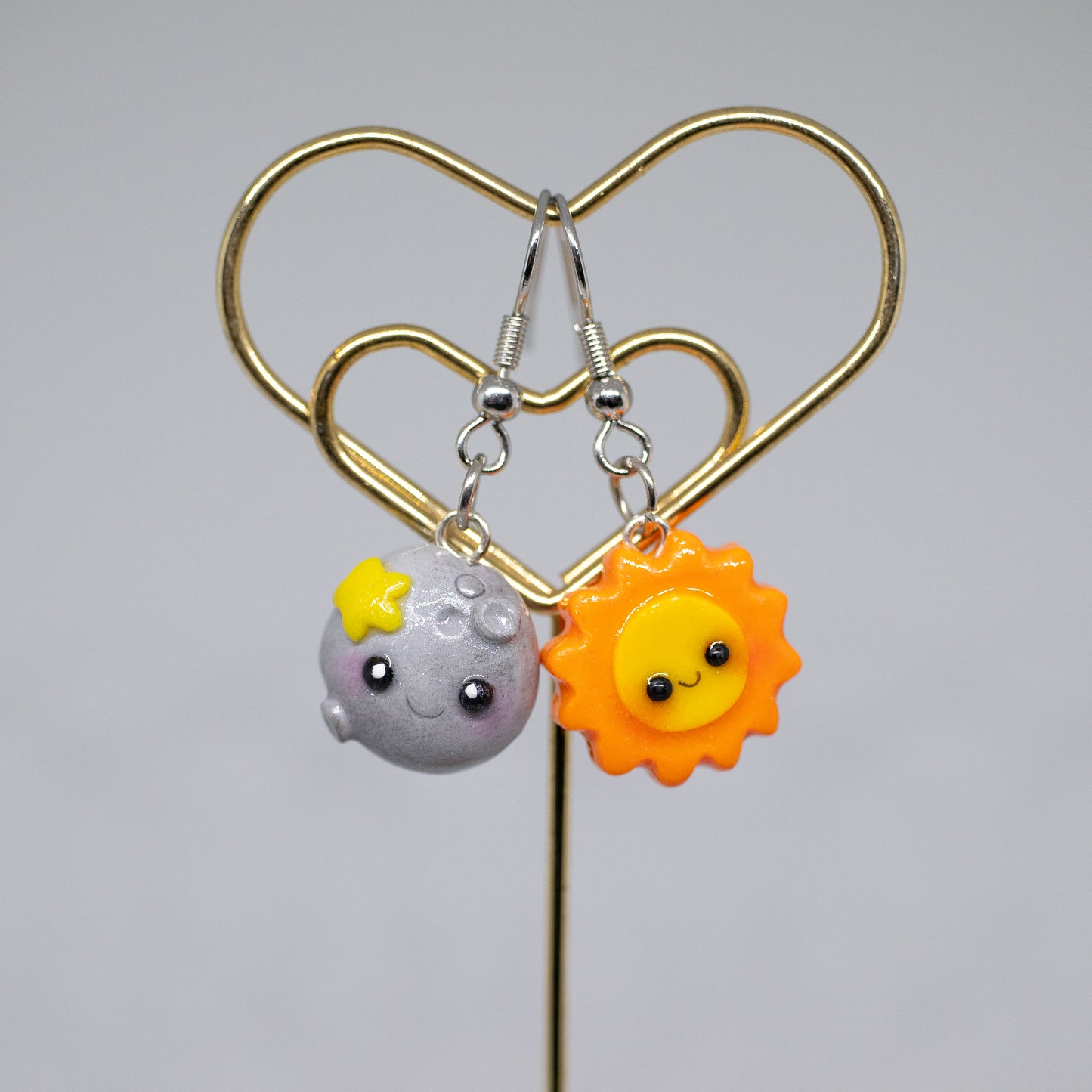 Our sun and moon clay charms as a pair of earrings.
