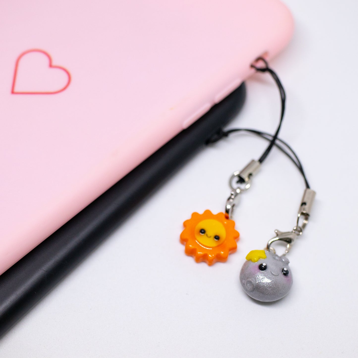 Our sun and moon clay charms on phone cases. These matching charms both have cute happy faces and pink blush.