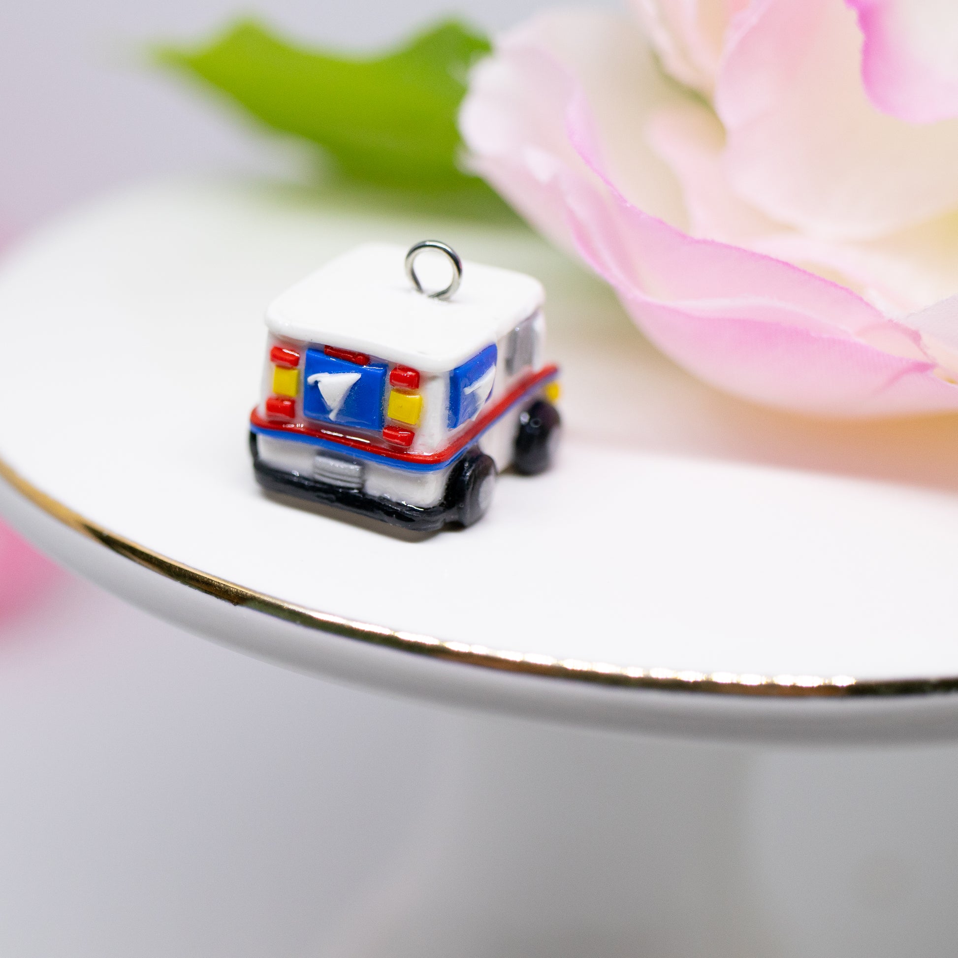 A tiny charm replica of an all too familiar truck that we see every day. Inspired by the USPS, this kawaii postal truck is boxy and cute with details on each side!