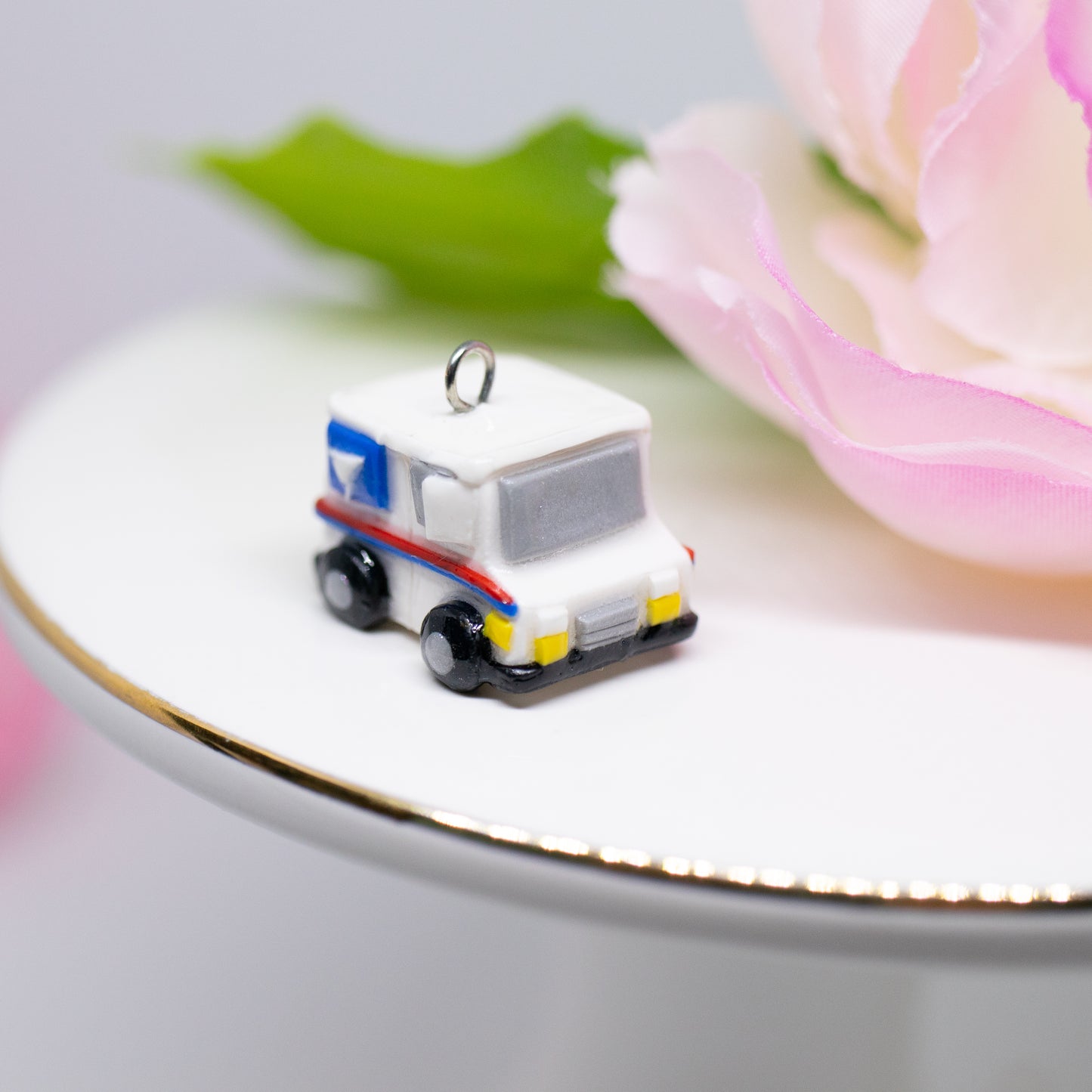 A tiny charm replica of an all too familiar truck that we see every day. Inspired by the USPS, this kawaii postal truck is boxy and cute with details on each side!