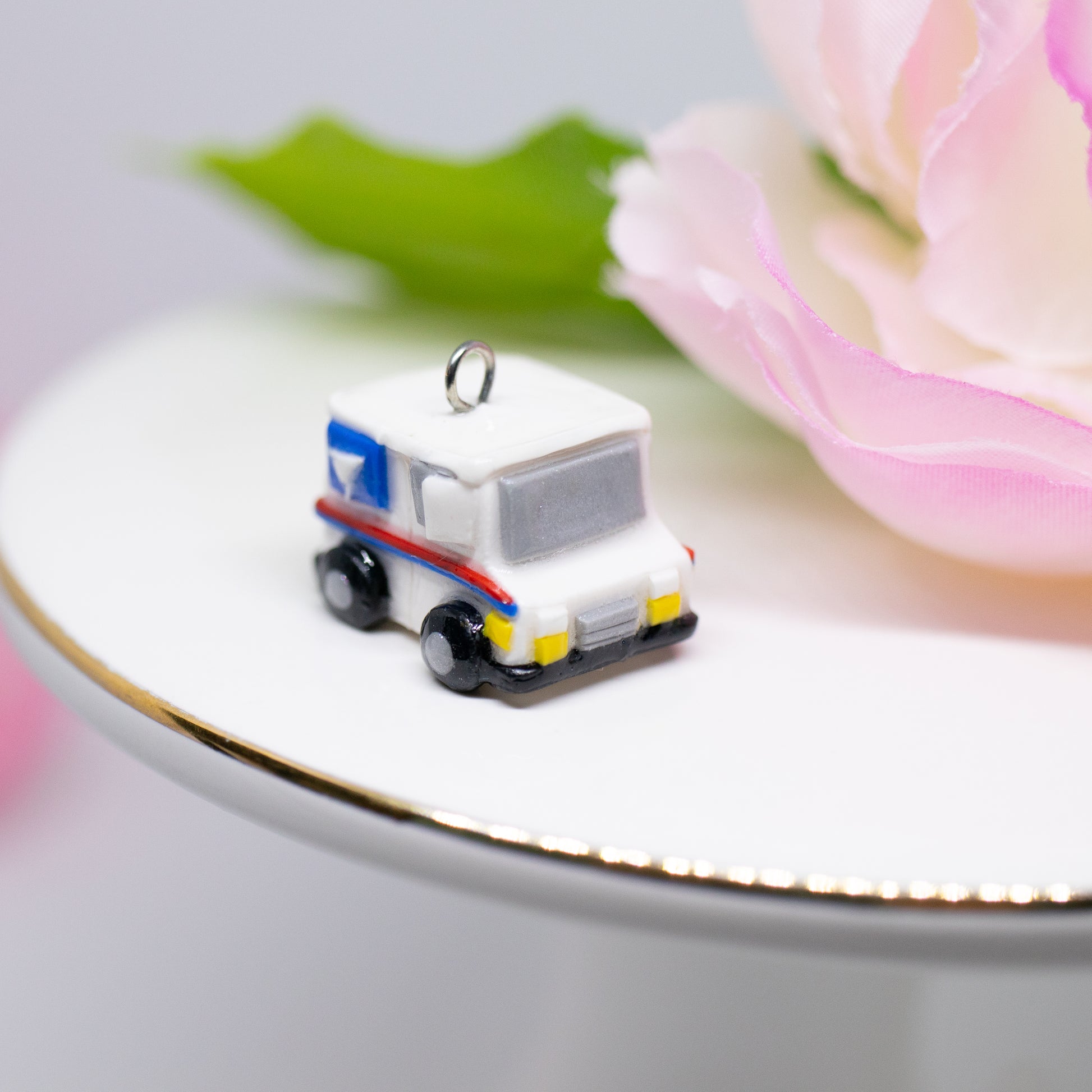 A tiny charm replica of an all too familiar truck that we see every day. Inspired by the USPS, this kawaii postal truck is boxy and cute with details on each side!