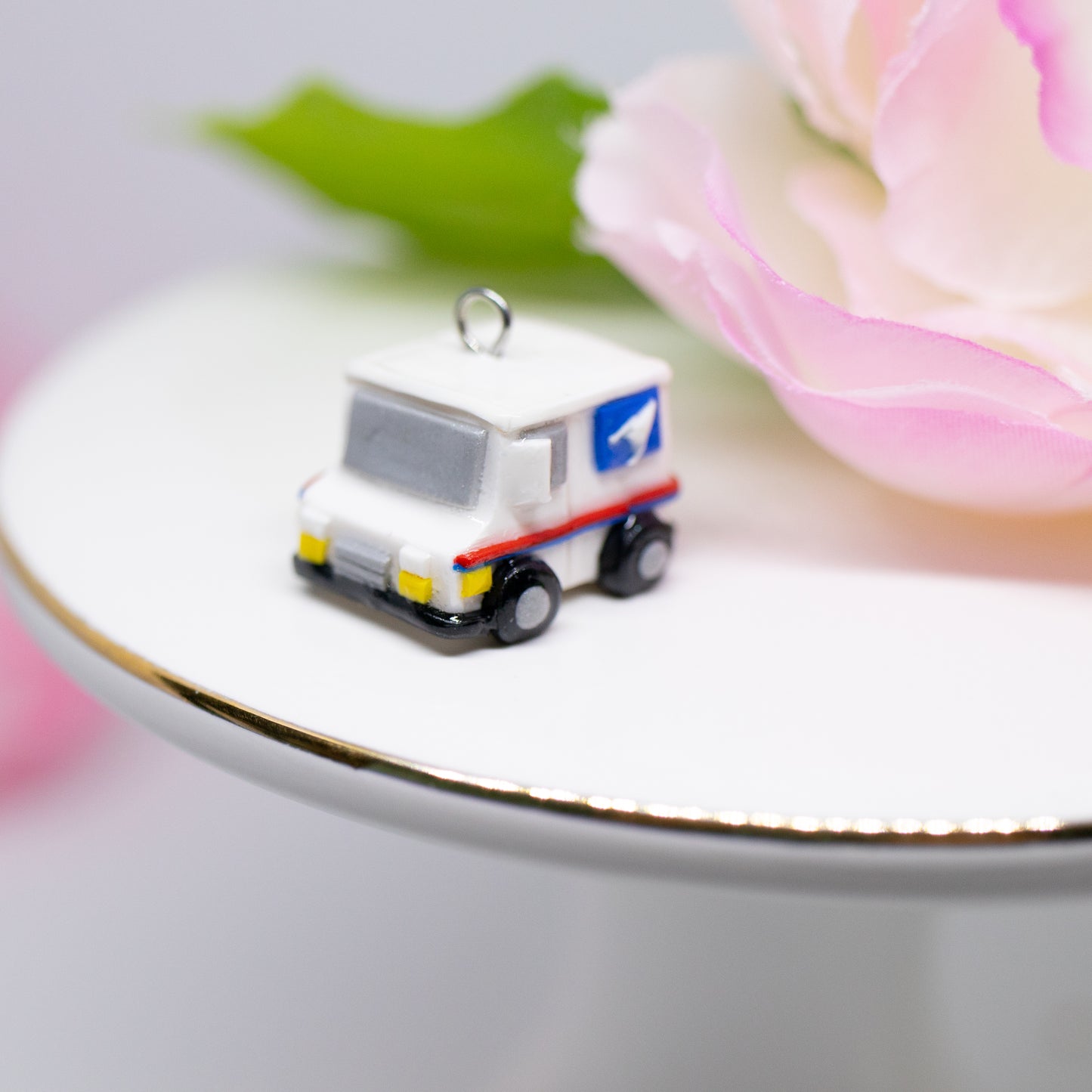 A tiny charm replica of an all too familiar truck that we see every day. Inspired by the USPS, this kawaii postal truck is boxy and cute with details on each side!
