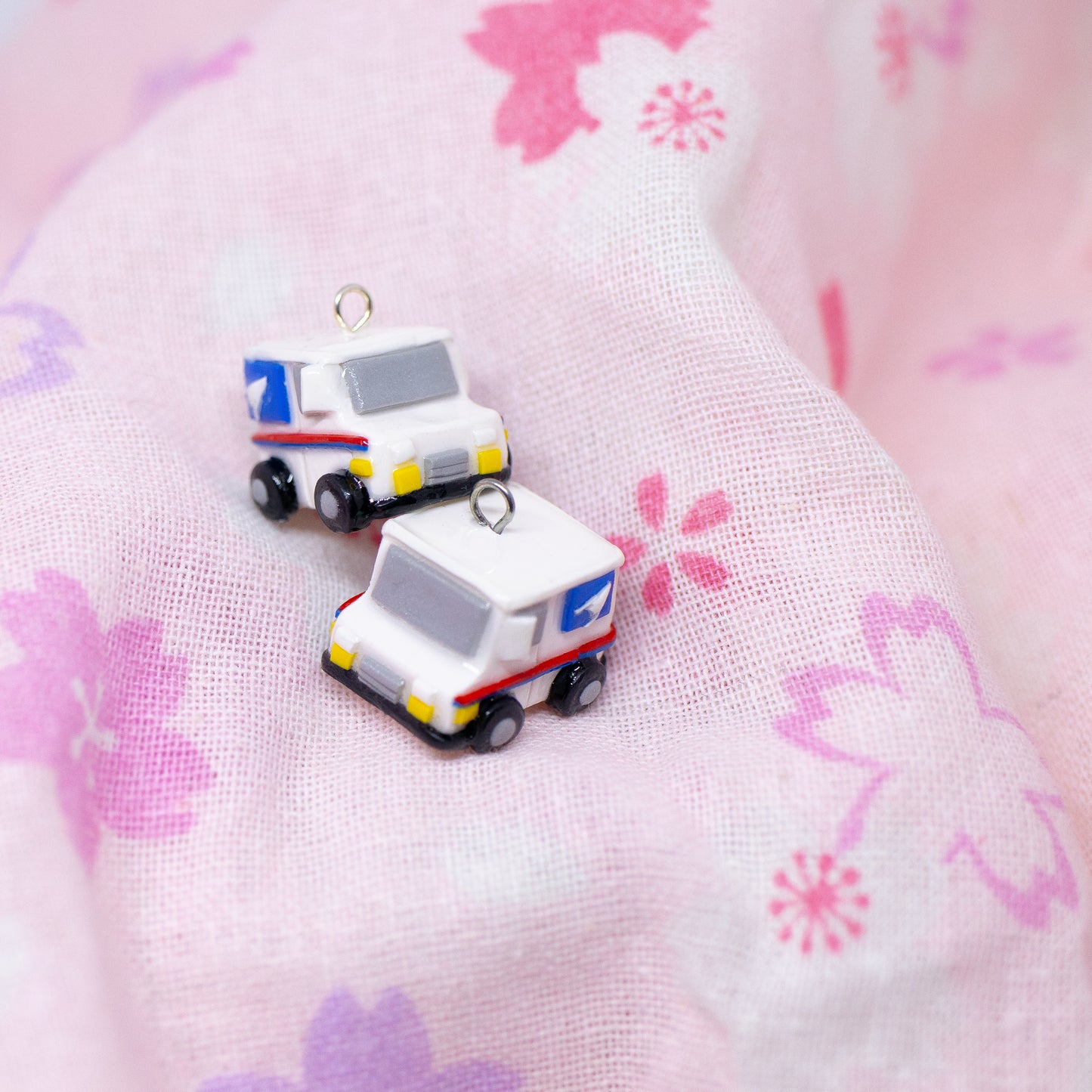 A tiny charm replica of an all too familiar truck that we see every day. Inspired by the USPS, this kawaii postal truck is boxy and cute with details on each side!
