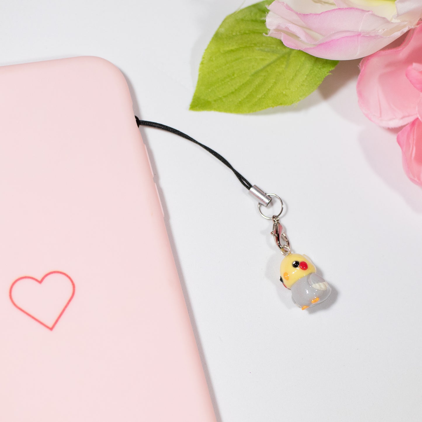 Handmade polymer clay cockatiel charms. This little bird has an orange beak/feet, and cute rosy-red cheeks.