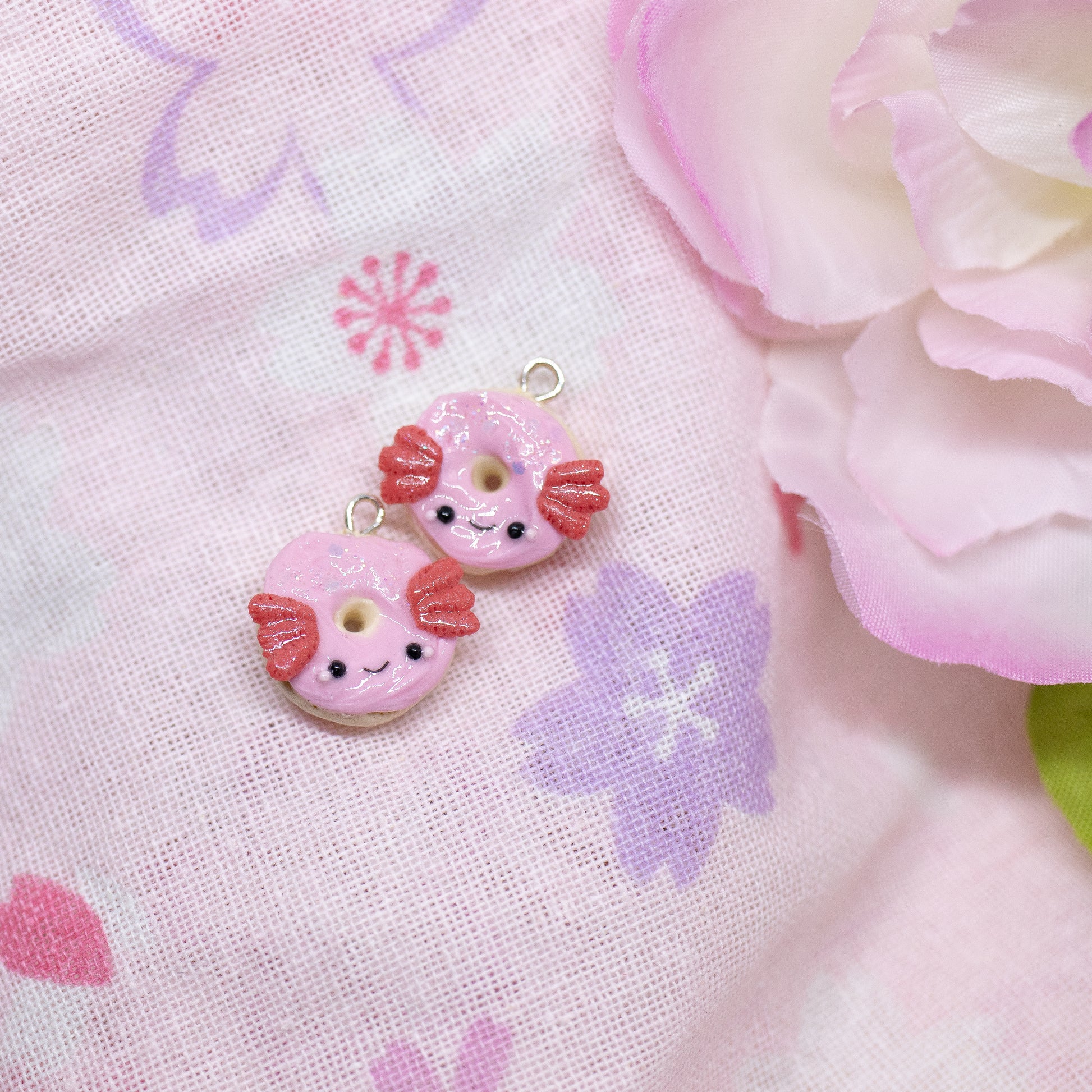 A simple, sparkly axolotl donut charm. This charm has a lot of tiny clay details, including like pink frosting and a tiny happy face. Handmade from polymer clay.