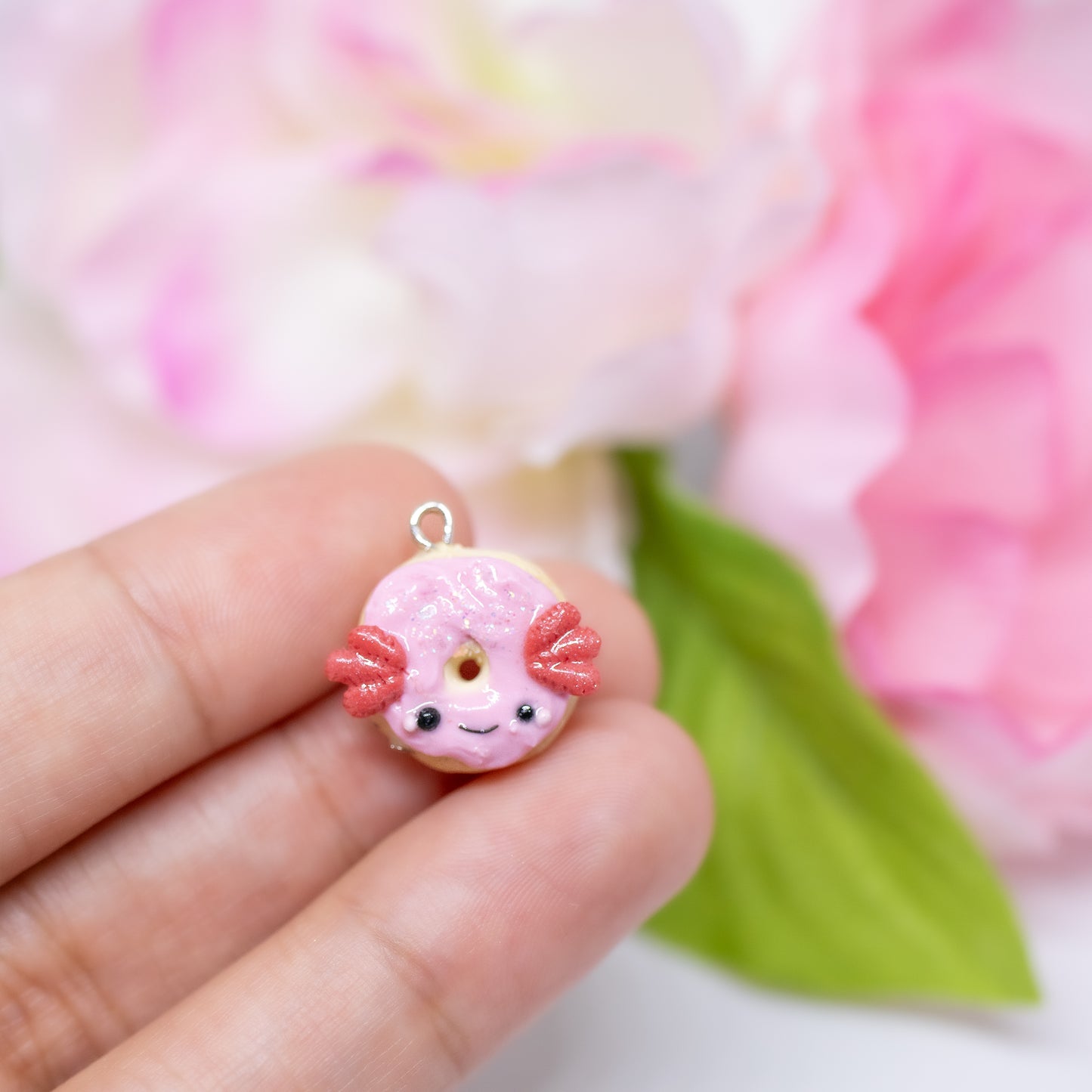 A simple, sparkly axolotl donut charm. This charm has a lot of tiny clay details, including like pink frosting and a tiny happy face. Handmade from polymer clay.