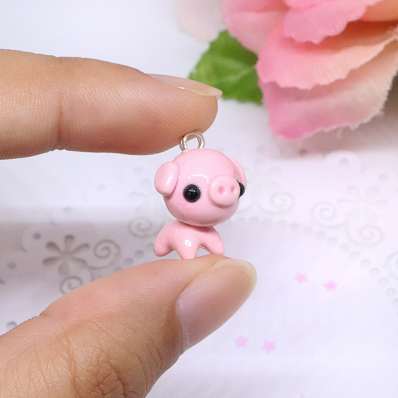 A cute, chubby pig charm. This charm has a lot of tiny details, including a snout and curly tail. Size: 0.75" wide x 0.75" tall