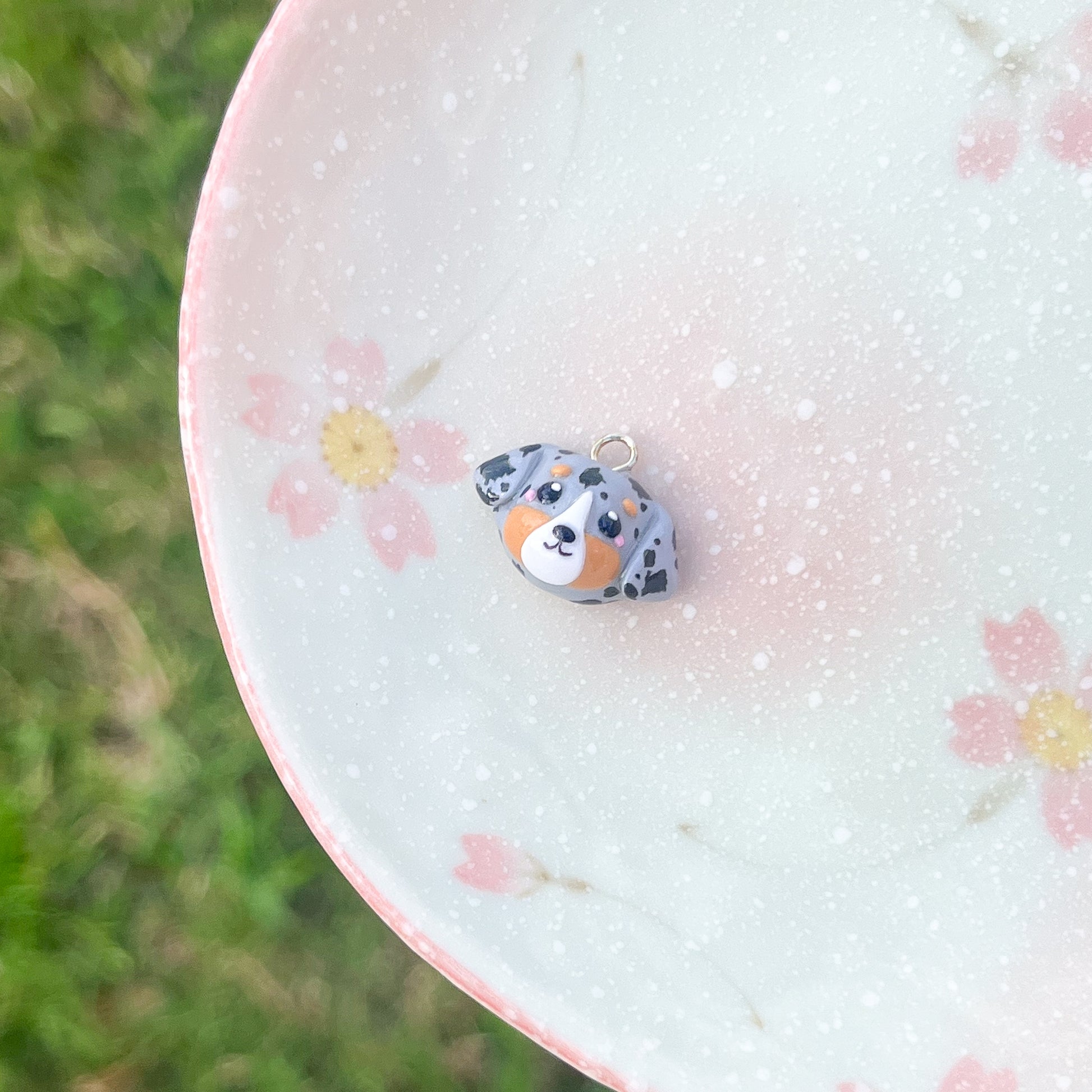 Handmade polymer clay australian shepherd dog charm. This charm has blushing cheeks and lots of spots painted on. A great gift for an australian shepherd dog owner!