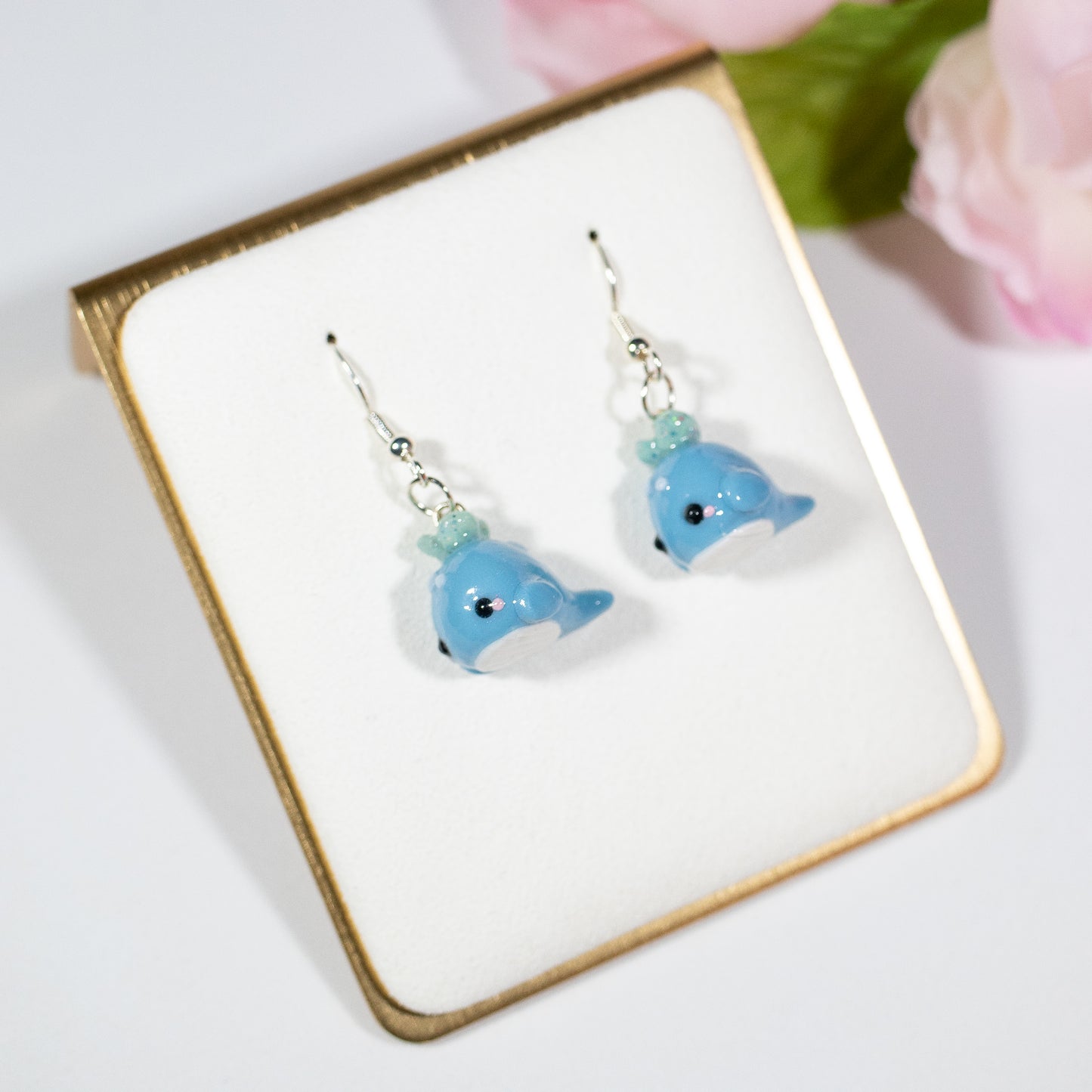 Handmade polymer clay blue whale charms. Available as a pair of earrings or as a charm. This little blue whale has spots on it's forehead and a glittery water splash coming out of its head.