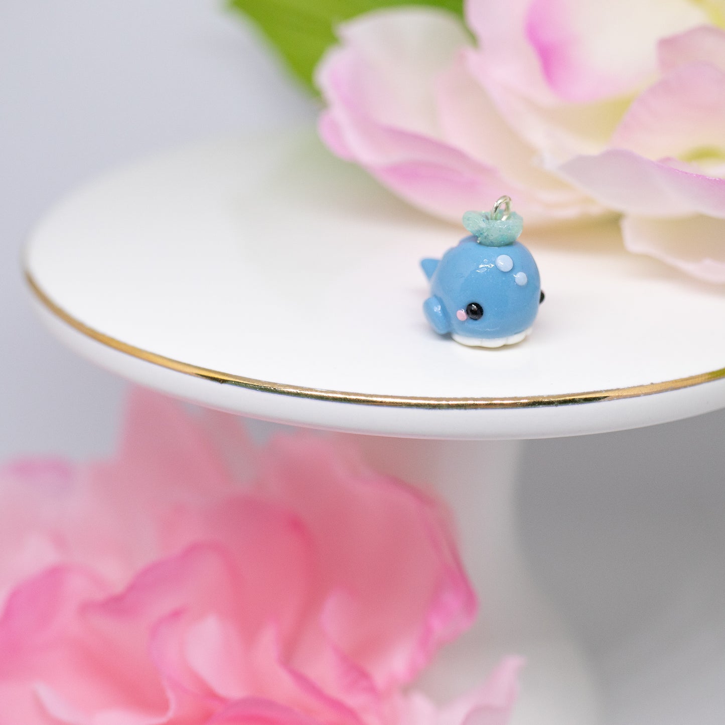 Handmade polymer clay blue whale charms. Available as a pair of earrings or as a charm. This little blue whale has spots on it's forehead and a glittery water splash coming out of its head.