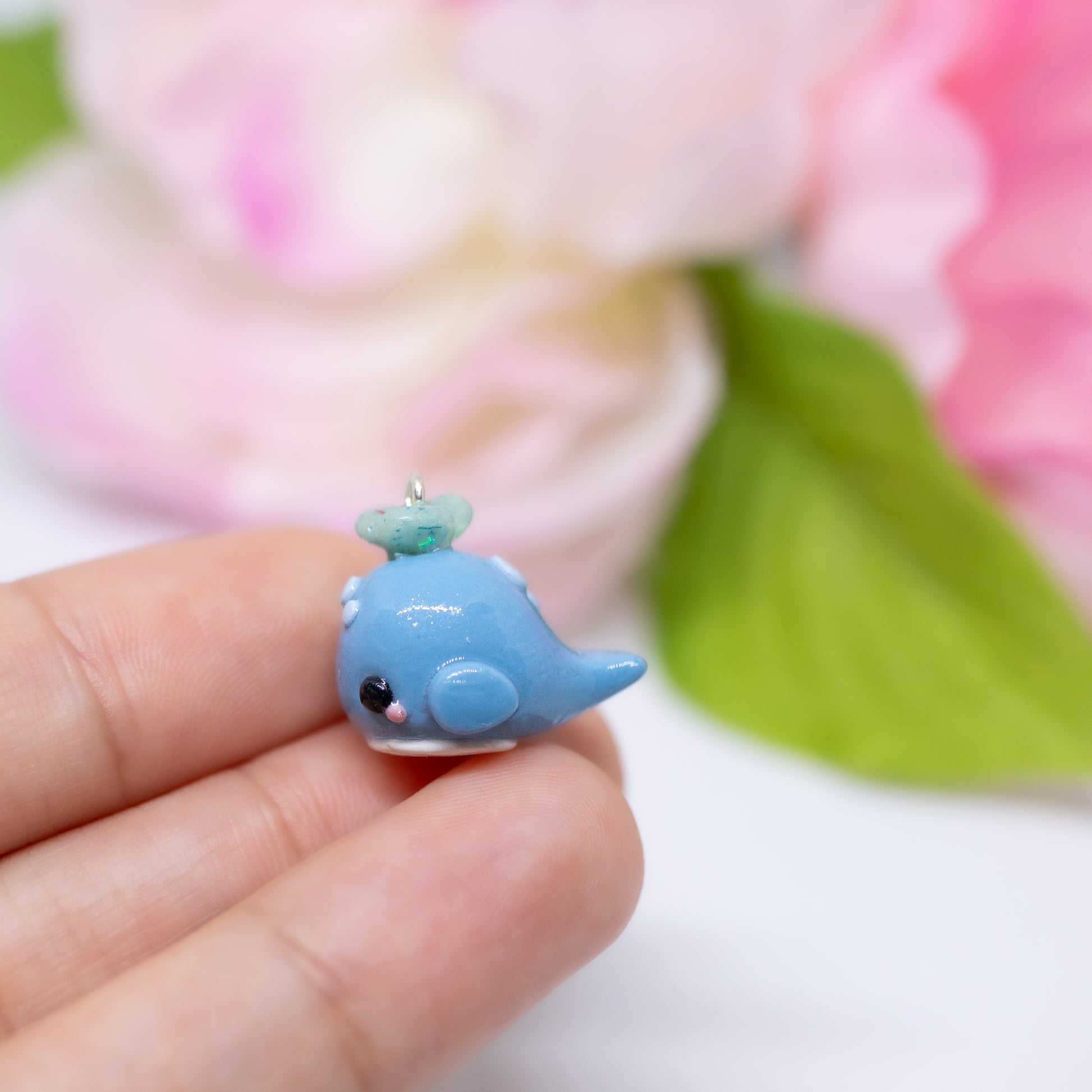 Handmade polymer clay blue whale charms. Available as a pair of earrings or as a charm. This little blue whale has spots on it's forehead and a glittery water splash coming out of its head.