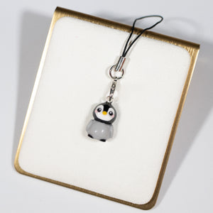 A simple grey and black penguin charm charm with pink cheeks and a little beak.