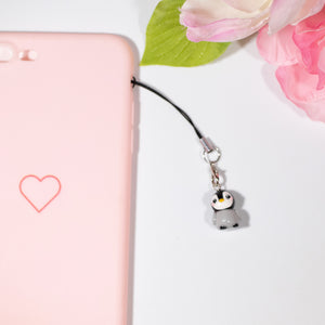 A simple grey and black penguin charm charm with pink cheeks and a little beak.
