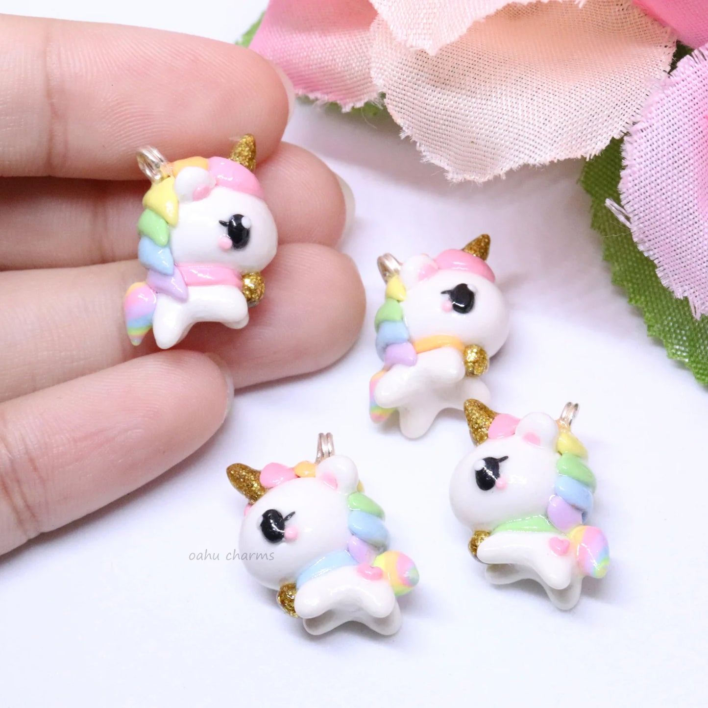 A chubby, rainbow unicorn with a gold bell and unicorn horn.  They can be used as phone charms, earrings or planner charms!