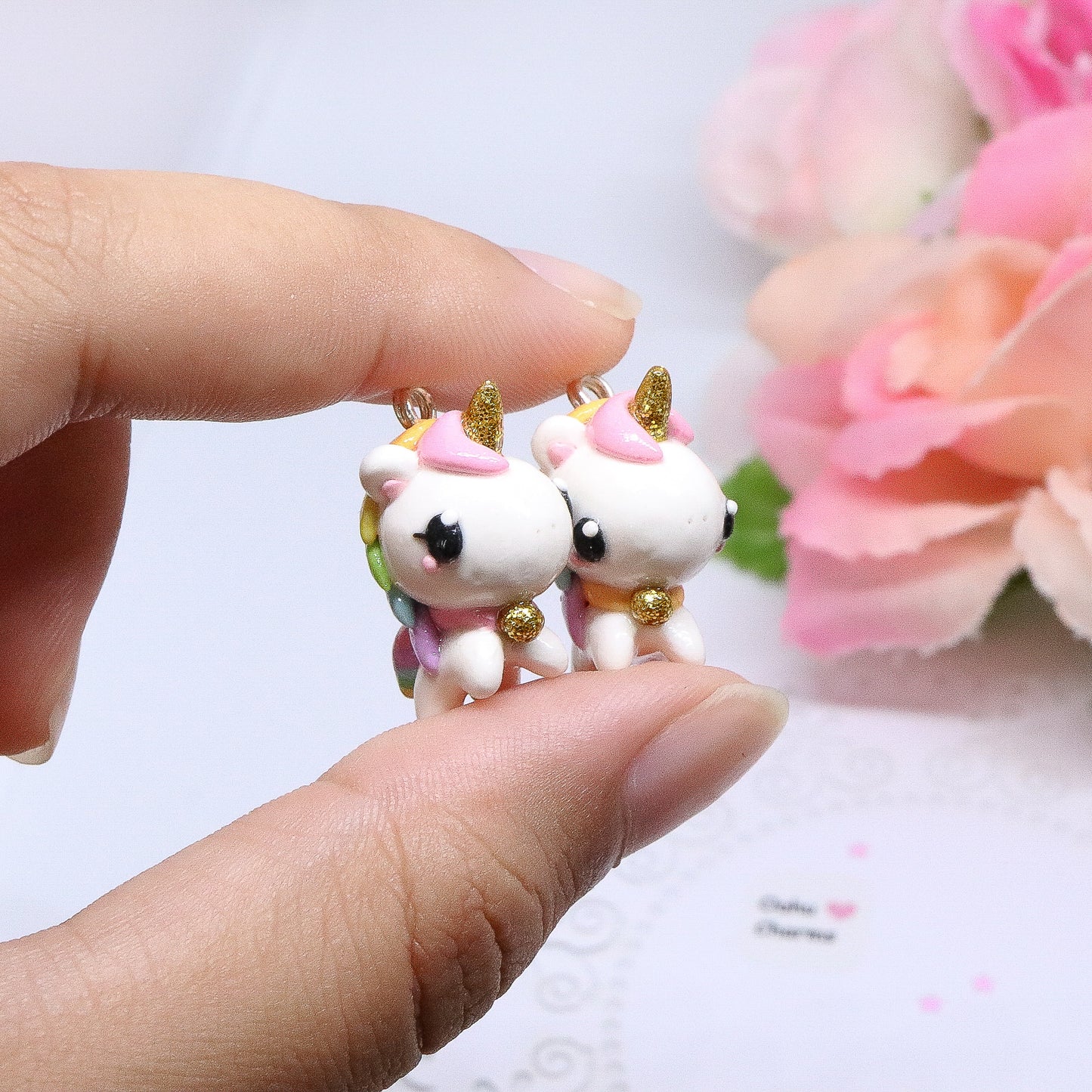 A chubby, rainbow unicorn with a gold bell and unicorn horn.  They can be used as phone charms, earrings or planner charms!