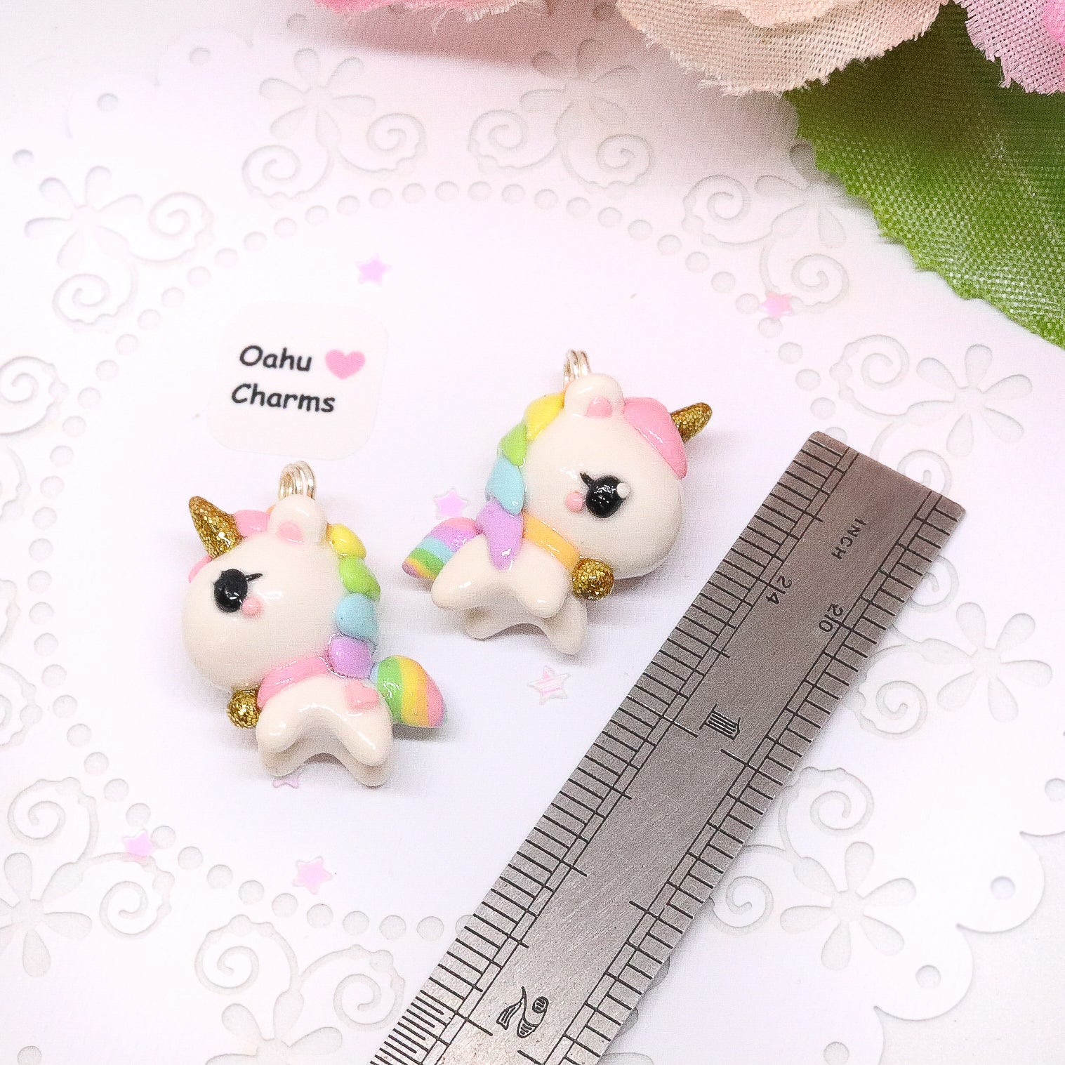 A chubby, rainbow unicorn with a gold bell and unicorn horn.  They can be used as phone charms, earrings or planner charms!