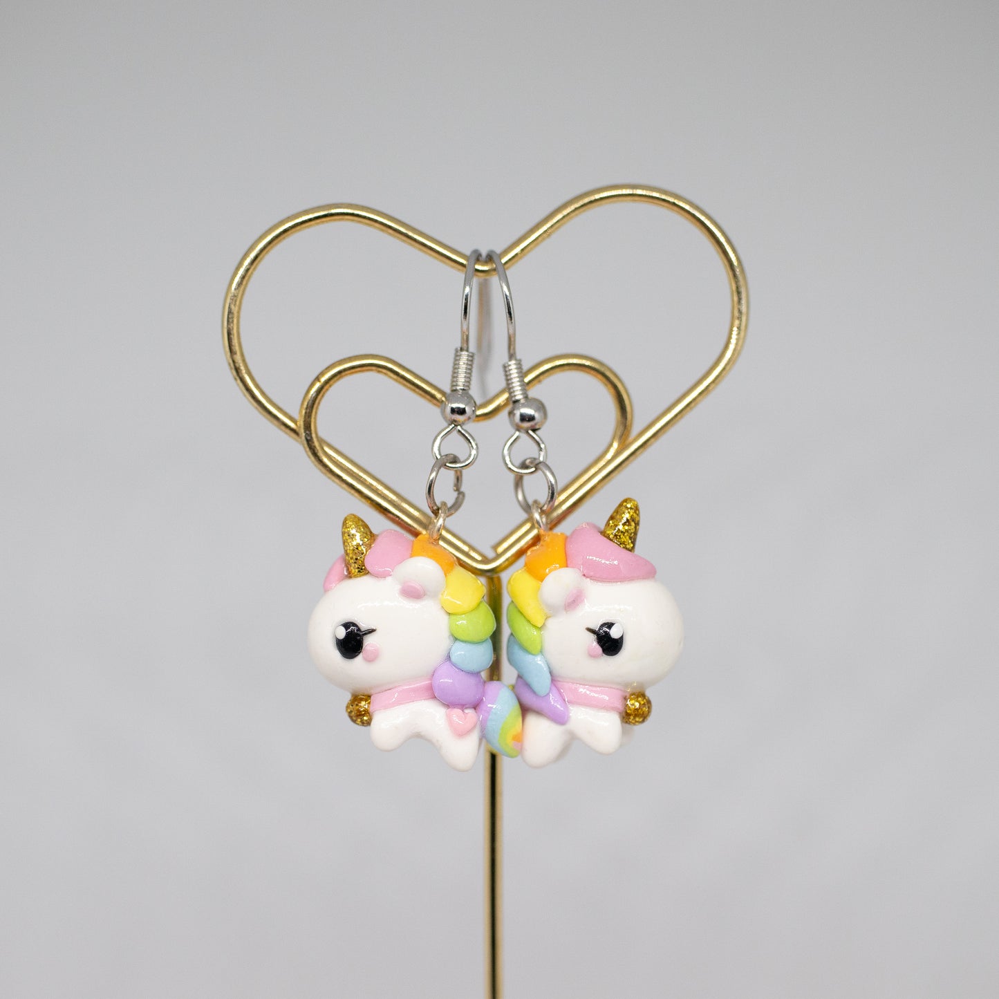 A chubby, rainbow unicorn with a gold bell and unicorn horn.  They can be used as phone charms, earrings or planner charms!