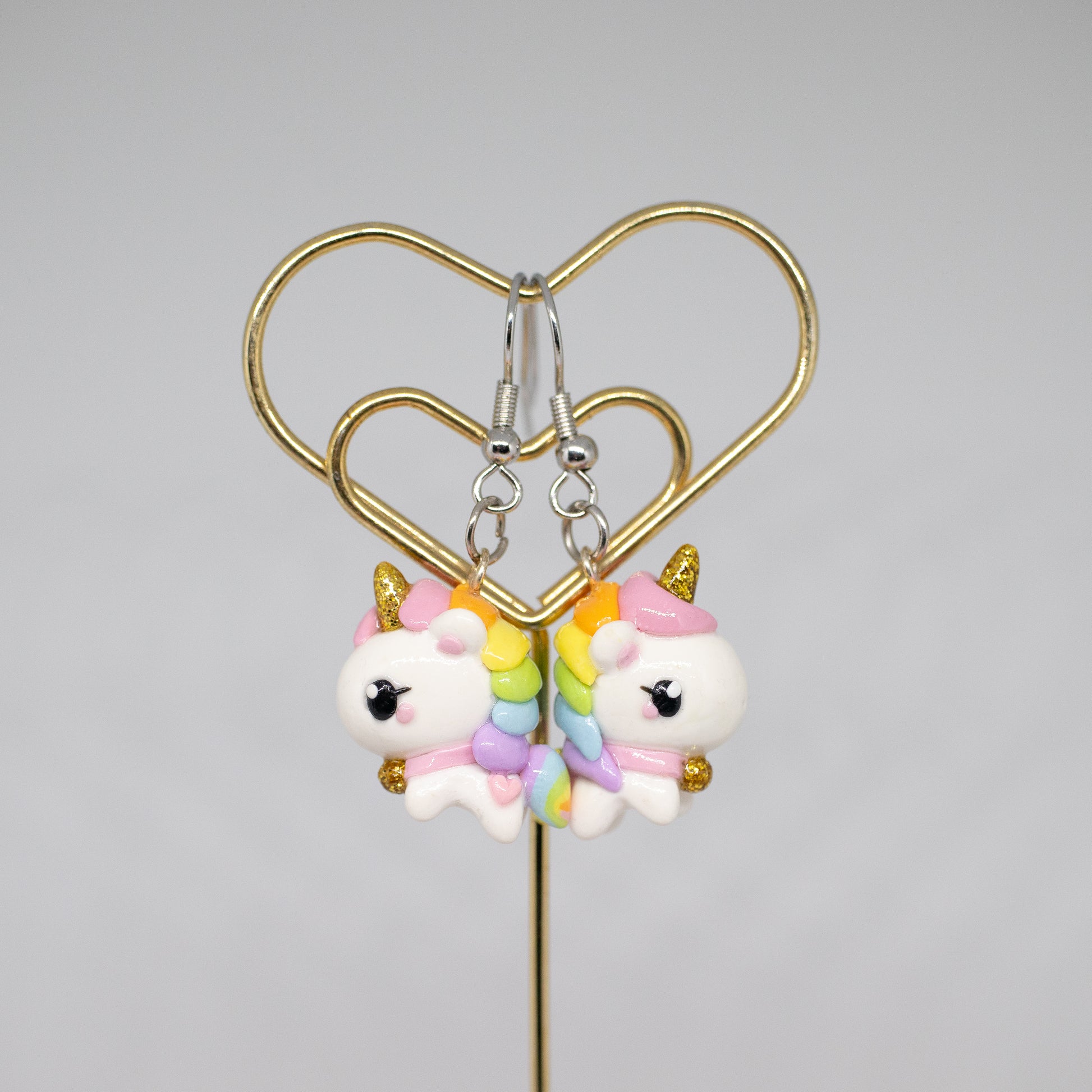 A chubby, rainbow unicorn with a gold bell and unicorn horn.  They can be used as phone charms, earrings or planner charms!