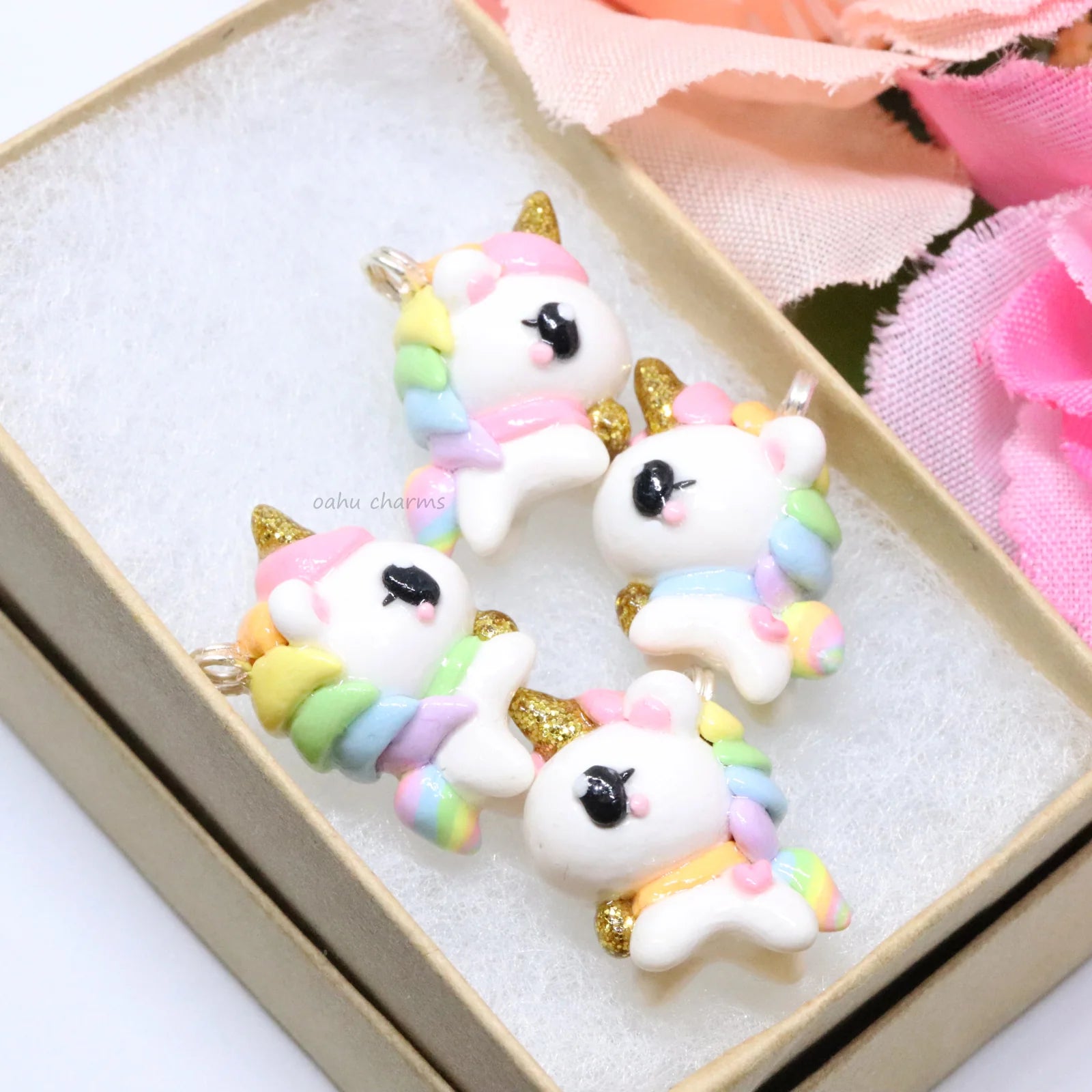 A chubby, rainbow unicorn with a gold bell and unicorn horn.  They can be used as phone charms, earrings or planner charms!