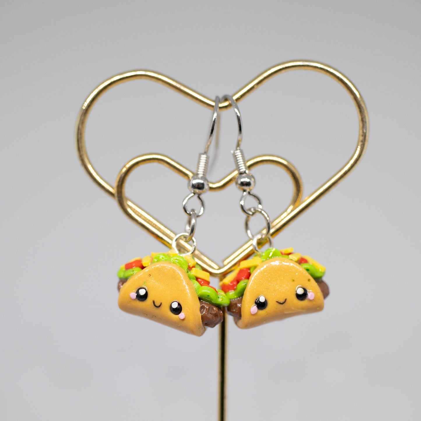 Handmade polymer clay taco charms. Available as a phone charm or pair of earrings. This little taco has a cute smiling face with a lot of toppings like tomatio, cheese and lettuce.