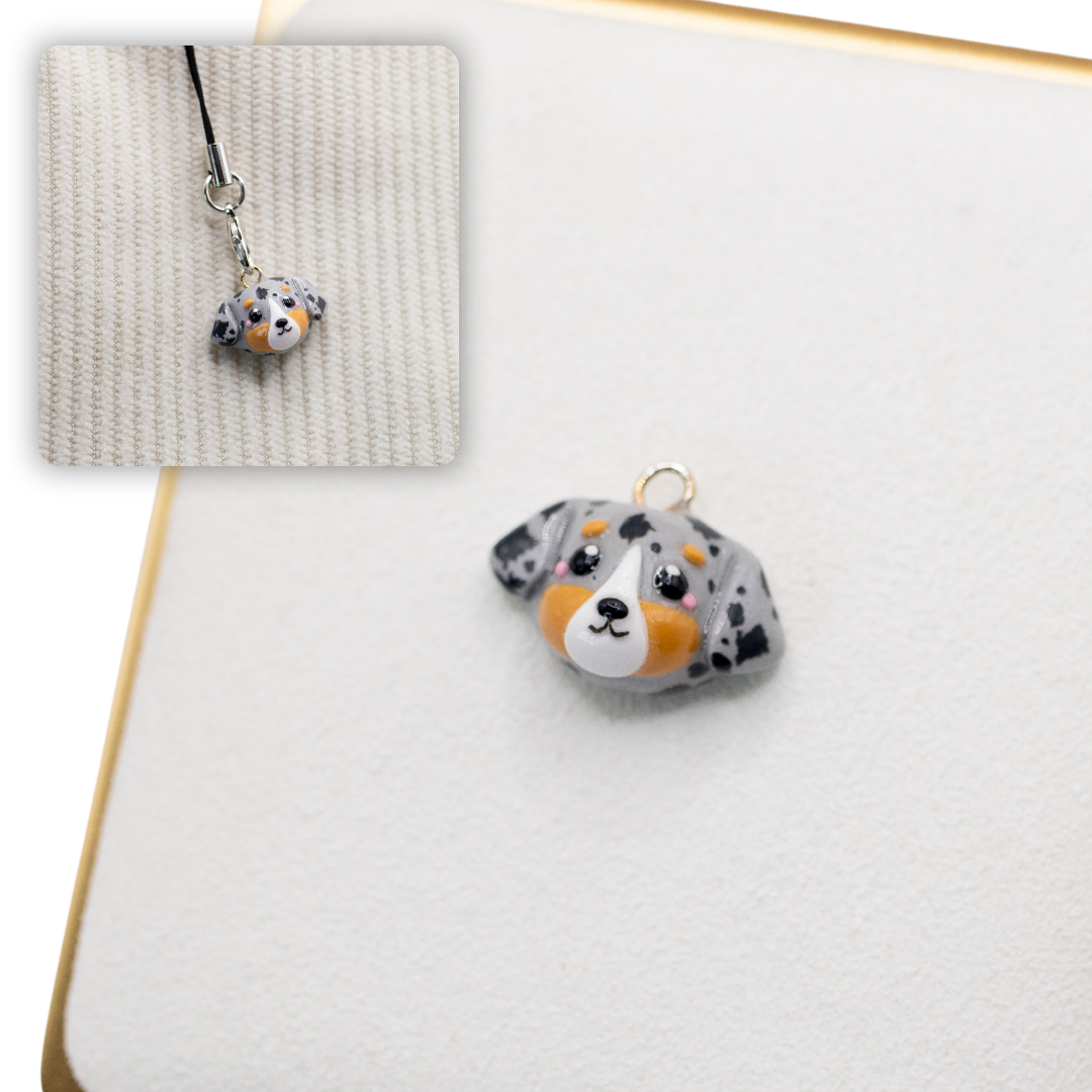 A picture of an australian shepherd dog polymer clay dog charm against a white background, with a 2nd smaller photo of the same dog charm being hung with a phone strap against a textured background.