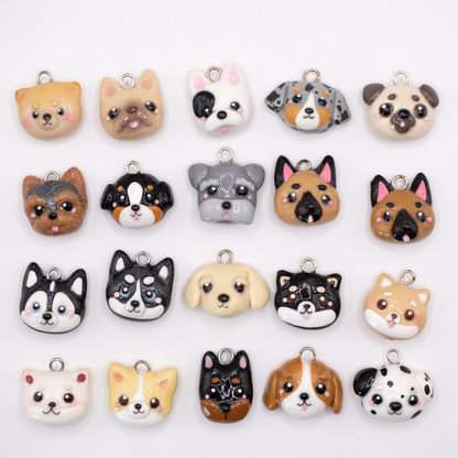 Collection of  20 different handmade clay dog charms on a white background.