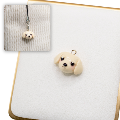 A picture of a golden retriever dog polymer clay dog charm on a white display with a gold border. There is a 2nd smaller photo of the same dog charm being hung with a phone strap against a textured background.