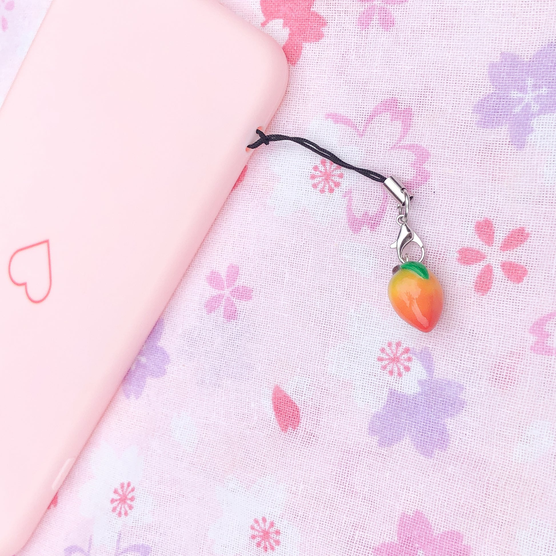 A mango charm topped with a dark green leaf. This charm is dusted with red and green chalk pastel for a colorful, realistic look. This charm can be attached to a cell phone, purse, or planner. Size: 0.5” wide x 0.625” tall