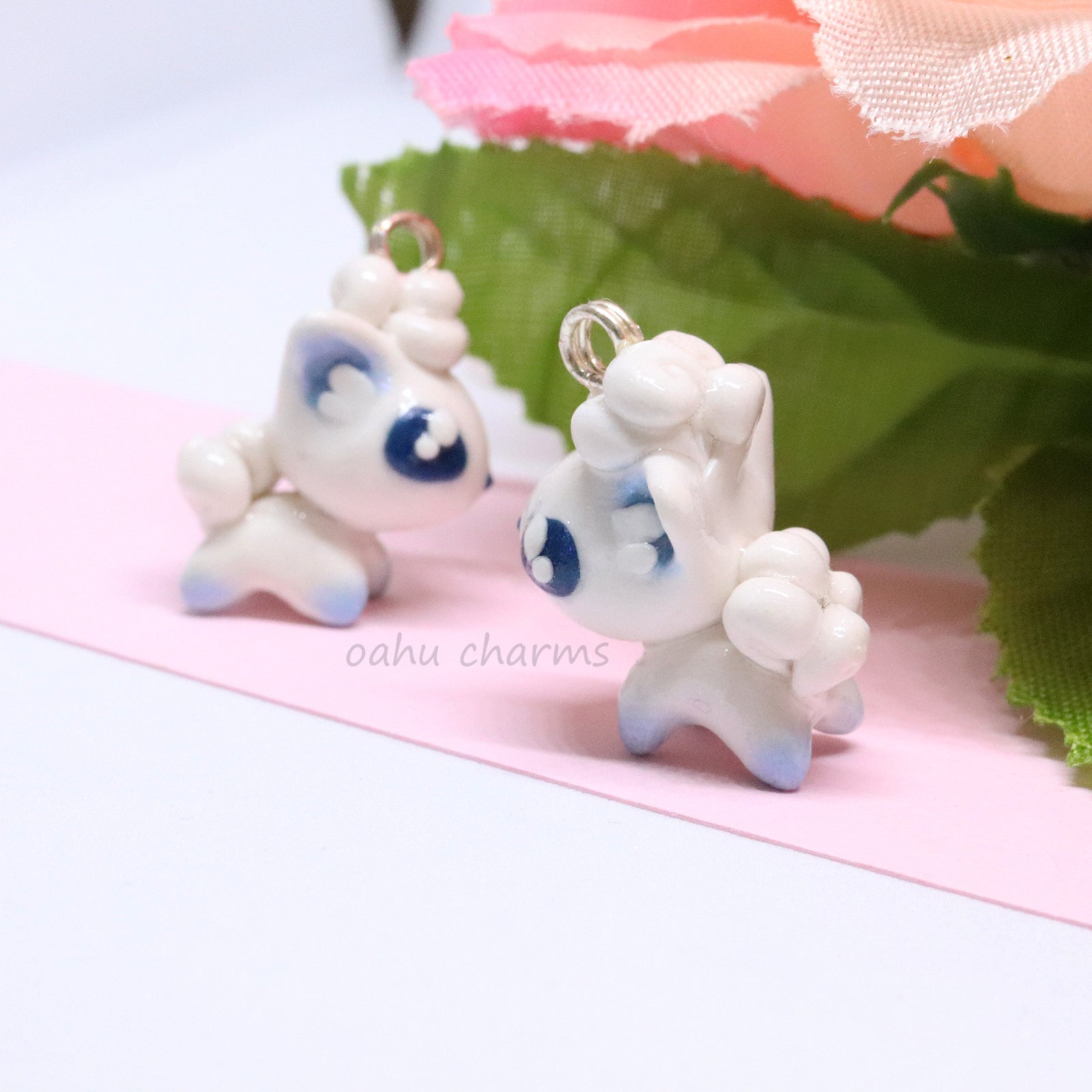 A cute, simple alolan vulpix clay charm.  This charm has a lot of little details on it like large, blue eyes and a big furry tail. Can be attached onto a phone, planner, or keychain.