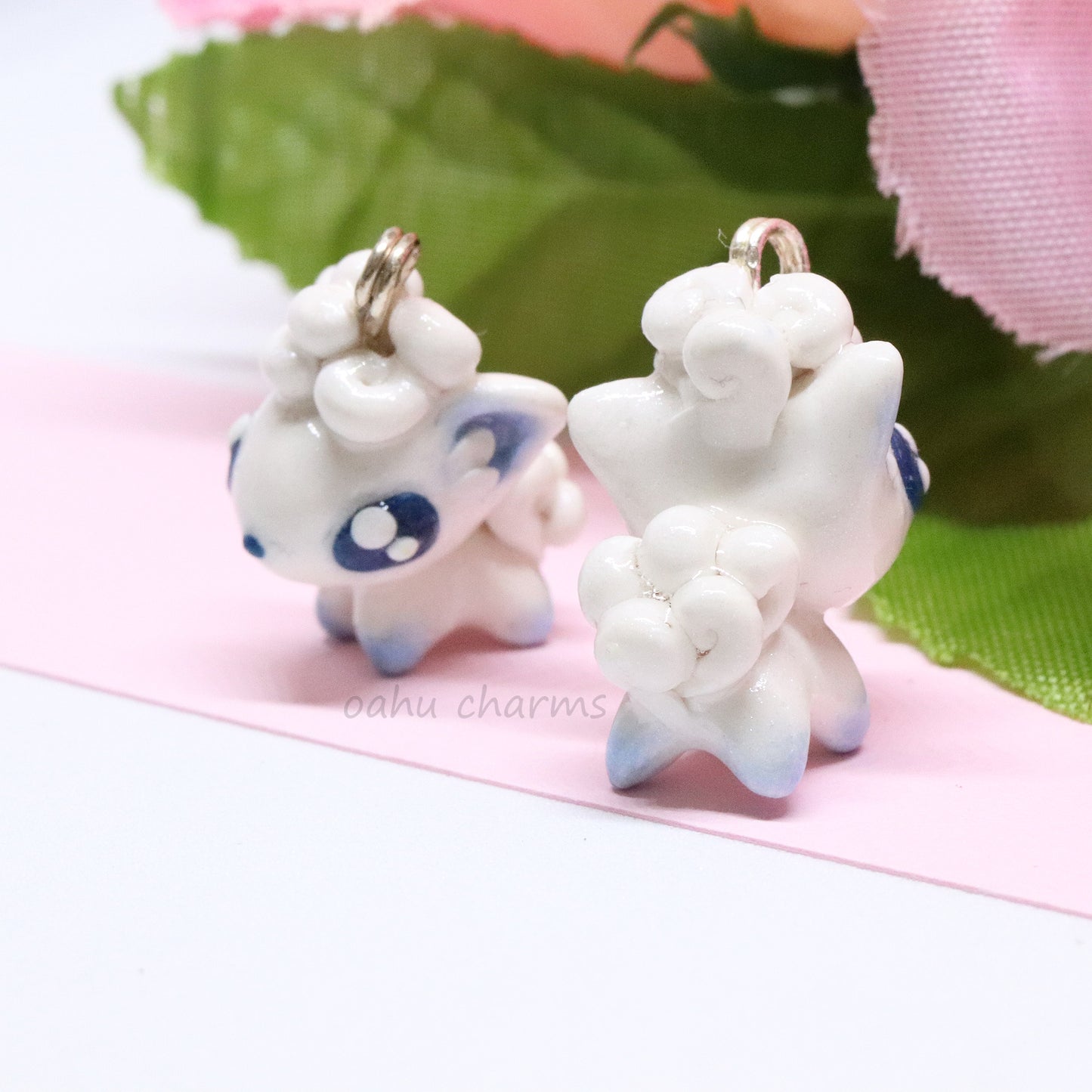 A cute, simple alolan vulpix clay charm.  This charm has a lot of little details on it like large, blue eyes and a big furry tail. Can be attached onto a phone, planner, or keychain.