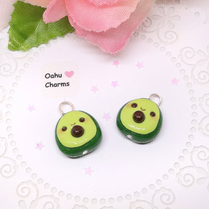 An avocado clay charm. This charm has a lot of tiny clay details, including a happy face and avocado seed in the middle. Handmade from polymer clay.