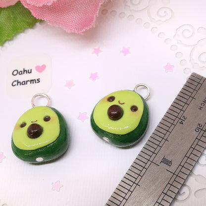 An avocado clay charm. This charm has a lot of tiny clay details, including a happy face and avocado seed in the middle. Handmade from polymer clay.